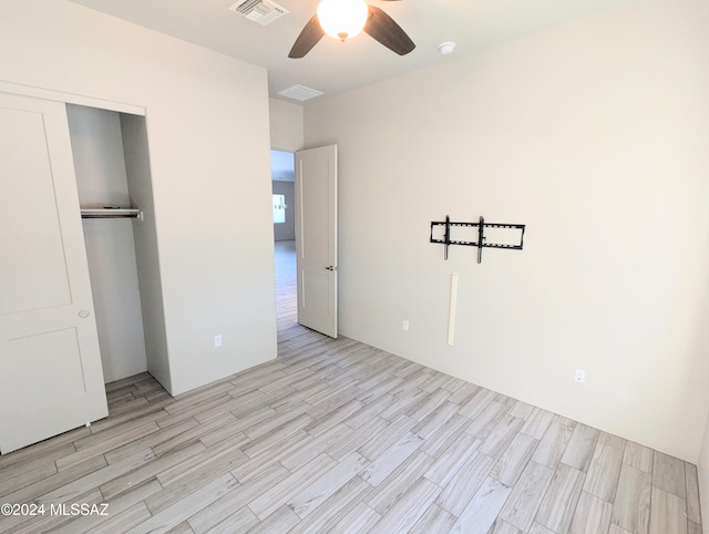 unfurnished bedroom with ceiling fan, a closet, and light hardwood / wood-style flooring