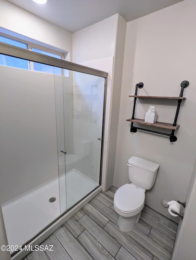 bathroom featuring an enclosed shower and toilet