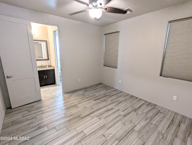 unfurnished bedroom with ceiling fan, sink, light hardwood / wood-style floors, and ensuite bath