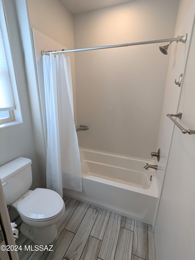 bathroom featuring toilet and shower / bath combination with curtain