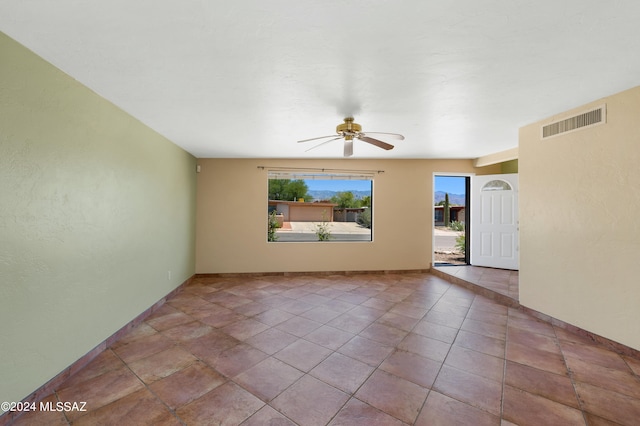 empty room featuring light tile patterned flooring and ceiling fan