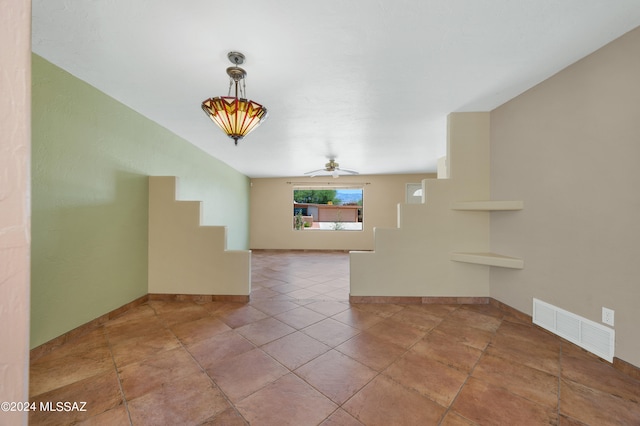 interior space featuring tile patterned flooring, vaulted ceiling, and ceiling fan