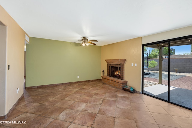 unfurnished living room with a brick fireplace and ceiling fan