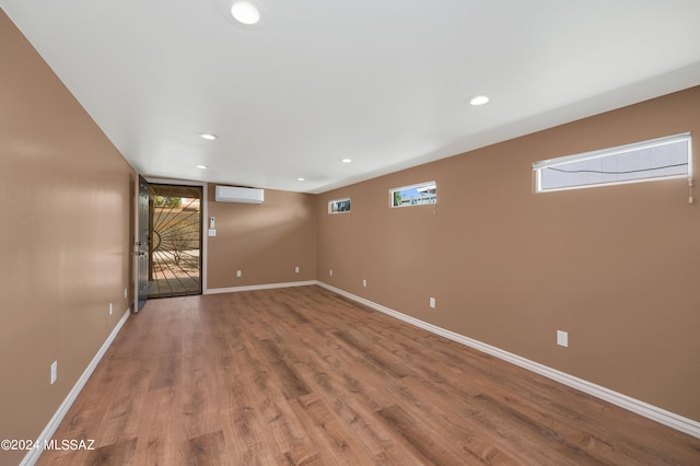 empty room with hardwood / wood-style flooring and a wall mounted air conditioner