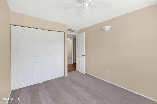 unfurnished bedroom featuring light carpet, a closet, and ceiling fan