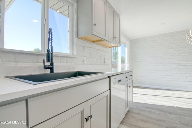 kitchen with white cabinetry, dishwasher, sink, and light wood-type flooring