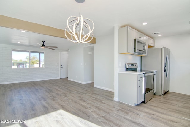 kitchen featuring white cabinets, hanging light fixtures, light wood-type flooring, appliances with stainless steel finishes, and brick wall