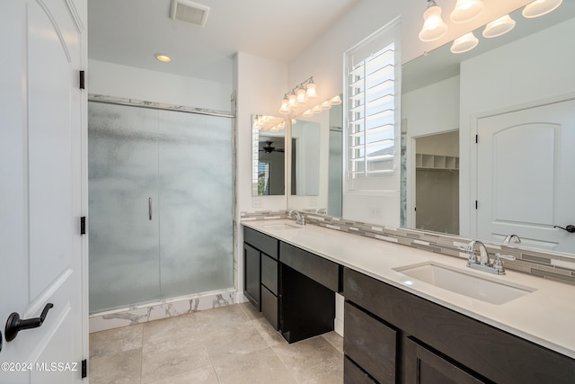 bathroom with an enclosed shower, vanity, tile patterned floors, and tasteful backsplash