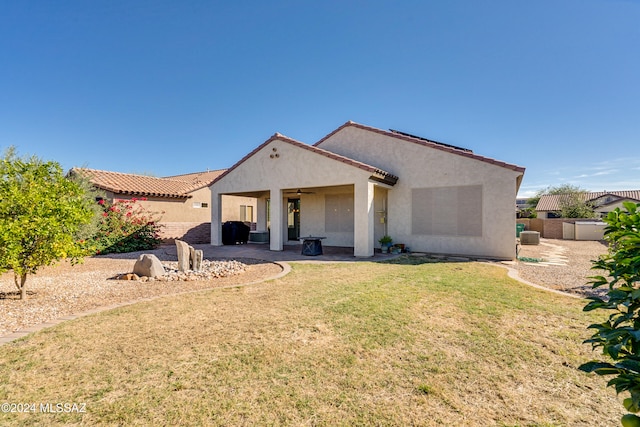 back of property featuring a lawn and a patio area