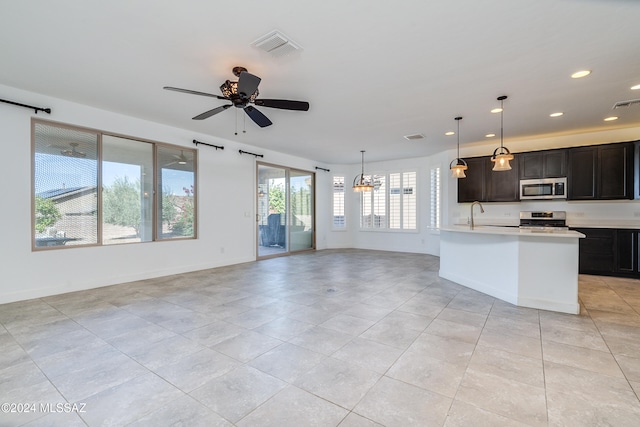 kitchen featuring appliances with stainless steel finishes, ceiling fan, light tile patterned floors, a kitchen island with sink, and pendant lighting