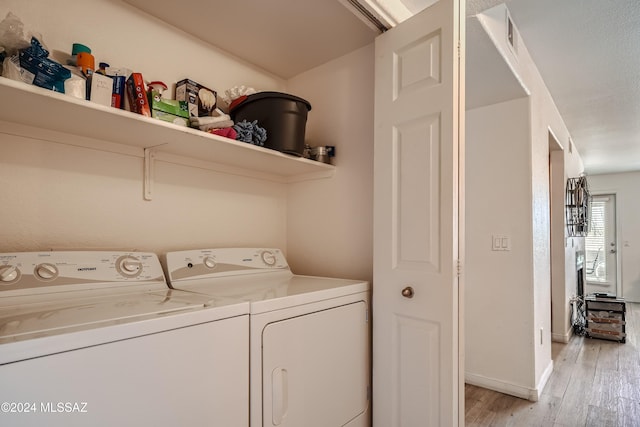 laundry room featuring light wood-type flooring and washing machine and clothes dryer