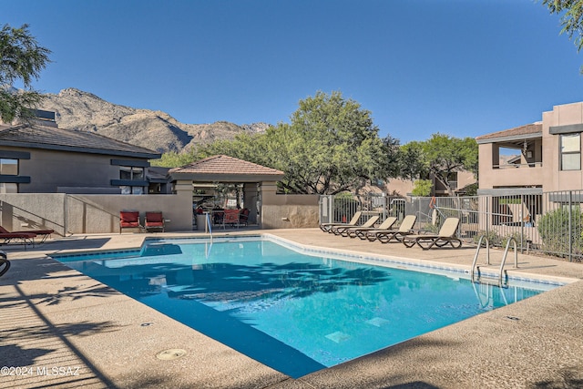 view of swimming pool with a patio area and a mountain view