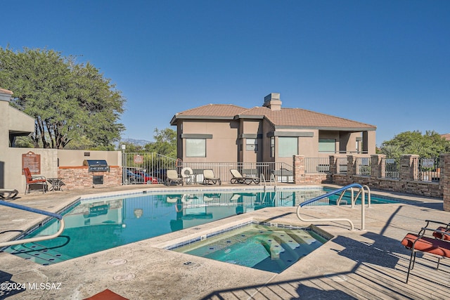 view of swimming pool with a hot tub and a patio