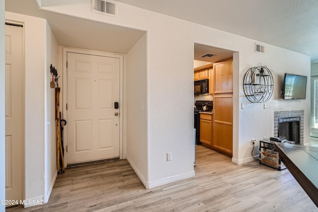 interior space with a brick fireplace and light wood-type flooring