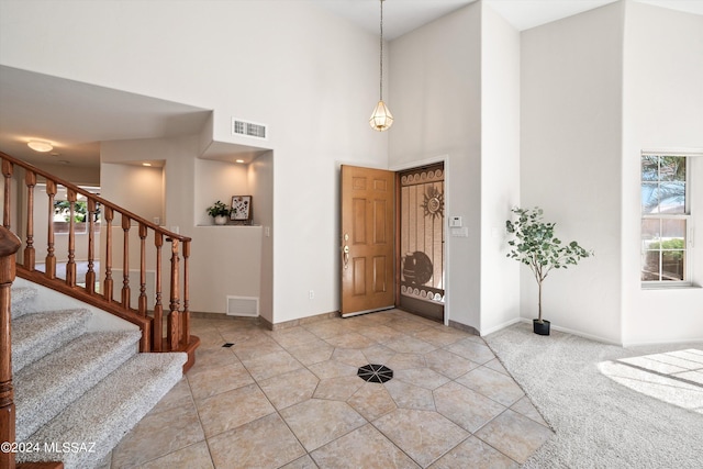 carpeted entryway featuring a high ceiling