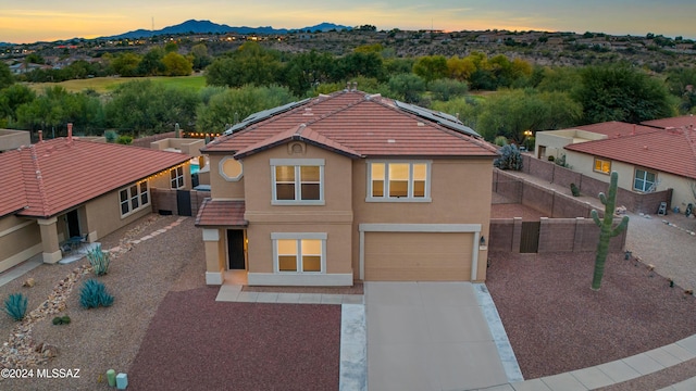 view of front of home with solar panels and a garage