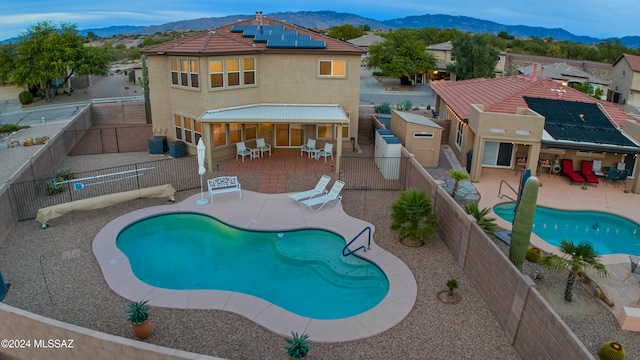 view of swimming pool featuring a mountain view, a patio, and cooling unit