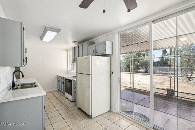 kitchen with gray cabinetry, white appliances, sink, ceiling fan, and light tile patterned floors