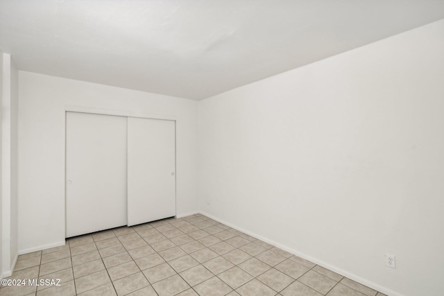 unfurnished bedroom featuring light tile patterned floors and a closet