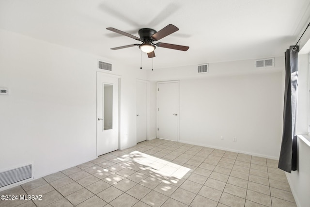 tiled spare room featuring ceiling fan