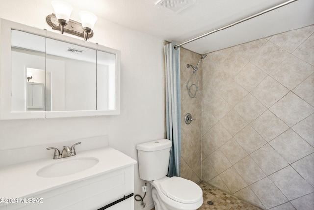 bathroom featuring a shower with shower curtain, vanity, and toilet