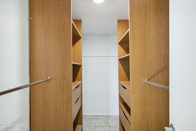 walk in closet with light tile patterned floors