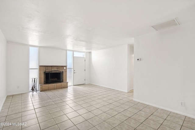 unfurnished living room with light tile patterned flooring, a fireplace, and a wealth of natural light