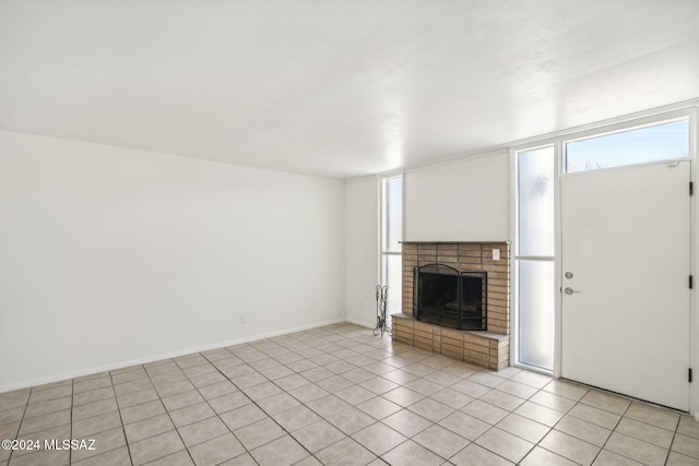 unfurnished living room featuring light tile patterned floors and a brick fireplace