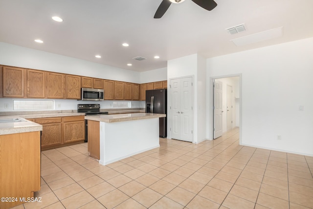 kitchen with light tile patterned flooring, ceiling fan, black fridge with ice dispenser, and a center island