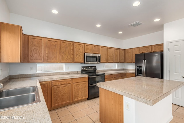 kitchen featuring a center island, sink, light tile patterned flooring, and stainless steel appliances