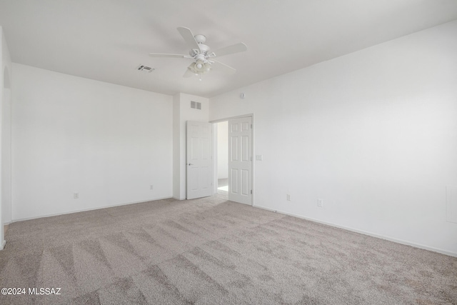 carpeted spare room featuring ceiling fan