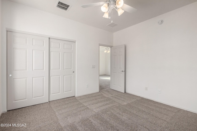 unfurnished bedroom with a closet, light colored carpet, and ceiling fan