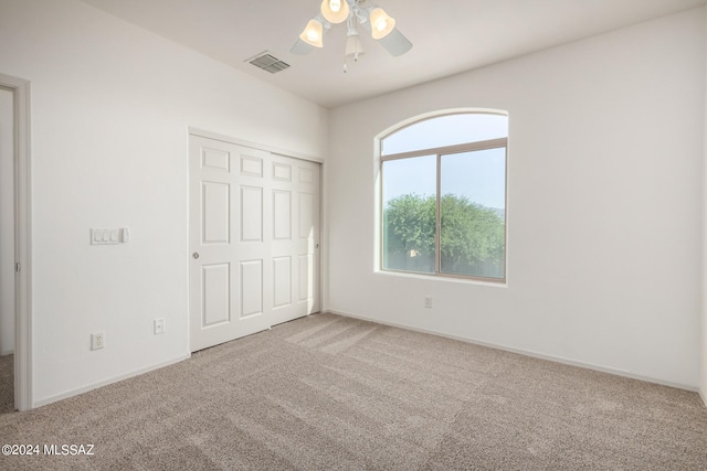 unfurnished bedroom featuring a closet, carpet, and ceiling fan