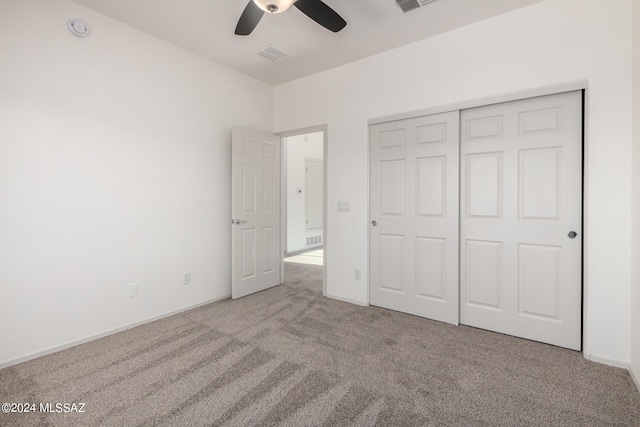 unfurnished bedroom with light carpet, ceiling fan, and a closet