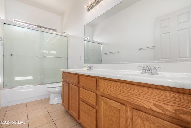 full bathroom featuring tile patterned floors, vanity, toilet, and enclosed tub / shower combo