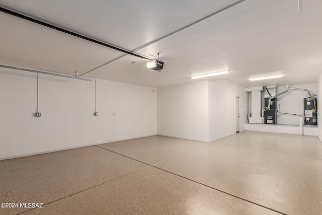 garage featuring heating unit, water heater, and a garage door opener