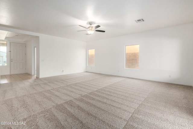 spare room with ceiling fan and light colored carpet