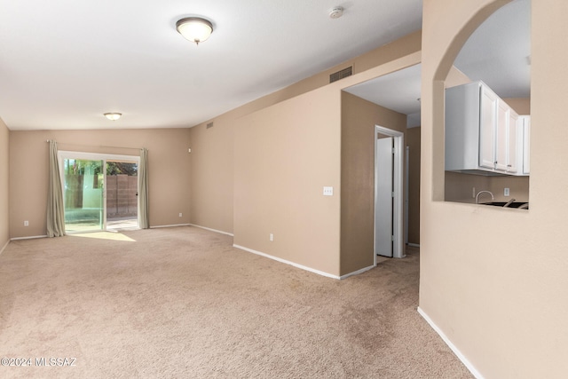 empty room featuring vaulted ceiling and light colored carpet