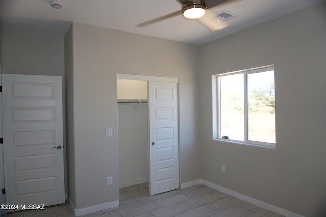 unfurnished bedroom with ceiling fan and a closet