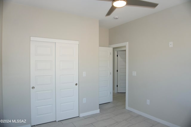 unfurnished bedroom with ceiling fan and a closet