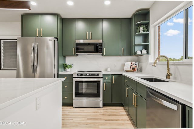 kitchen with green cabinetry, sink, a healthy amount of sunlight, and stainless steel appliances