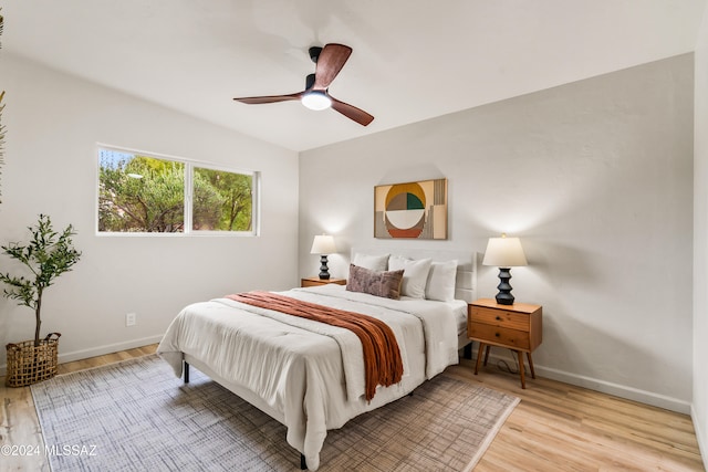 bedroom featuring light hardwood / wood-style floors, ceiling fan, and lofted ceiling