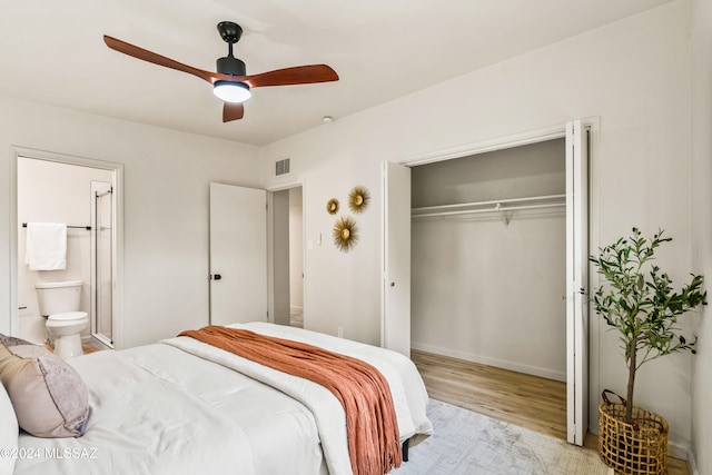 bedroom with ensuite bathroom, ceiling fan, a closet, and light wood-type flooring