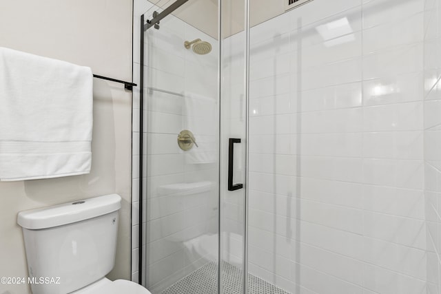 bathroom with toilet and a shower with door