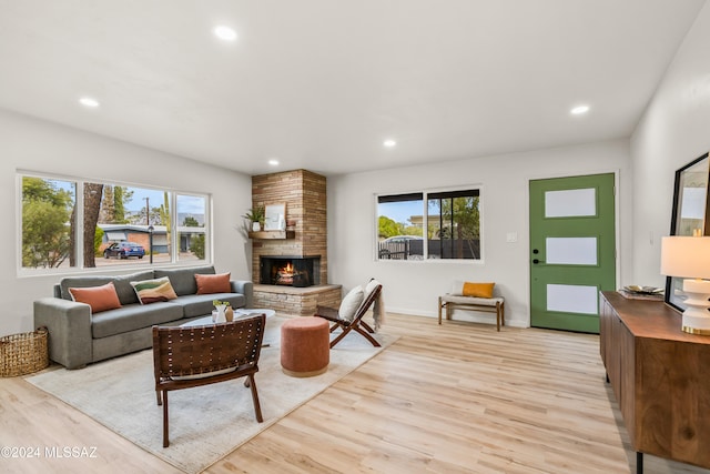 living room with a fireplace, plenty of natural light, and light hardwood / wood-style floors