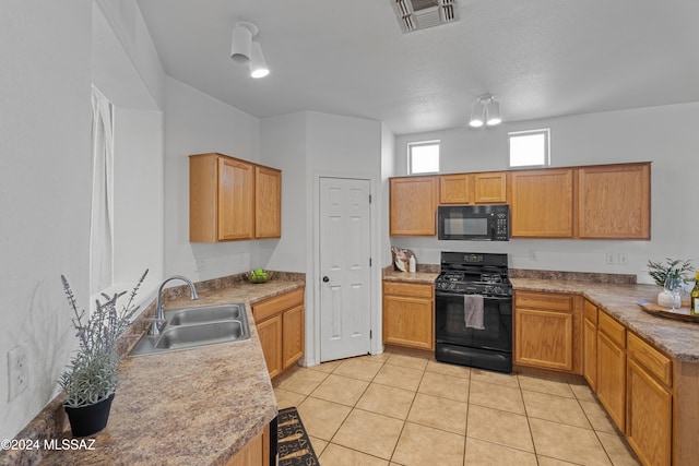 kitchen with black appliances, light tile patterned floors, visible vents, and a sink