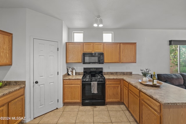 kitchen featuring light tile patterned floors, black appliances, a peninsula, and brown cabinets