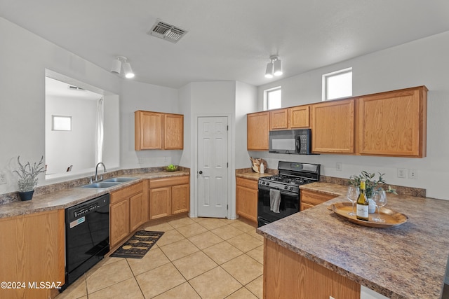 kitchen with light tile patterned floors, visible vents, a peninsula, black appliances, and a sink