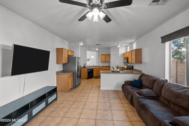 living area with light tile patterned floors, visible vents, and a ceiling fan