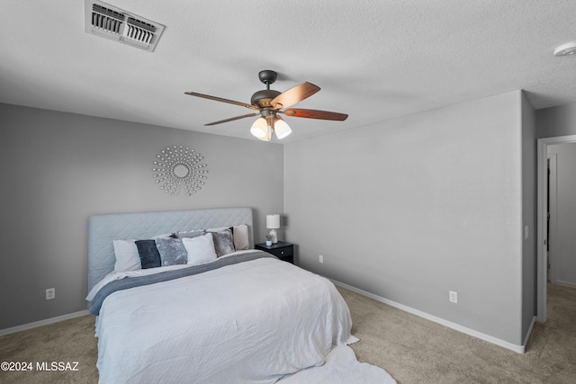 bedroom featuring a textured ceiling, ceiling fan, carpet floors, visible vents, and baseboards